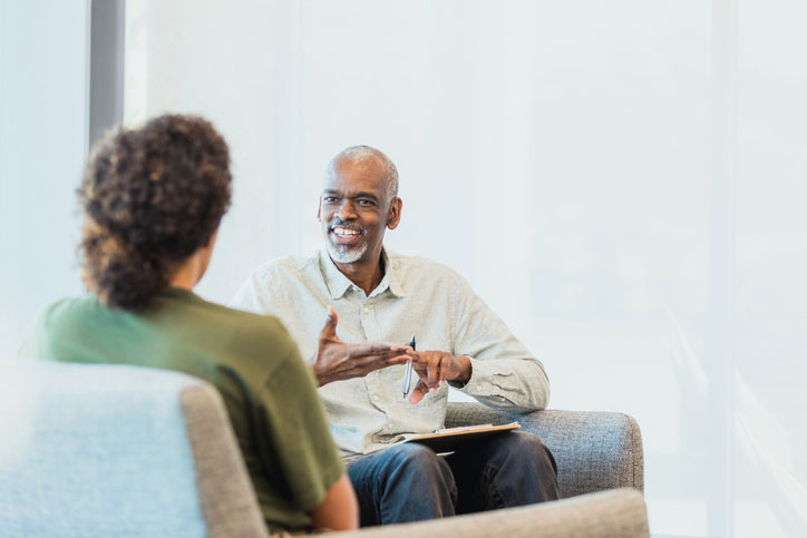 female therapist talking with older male therapist