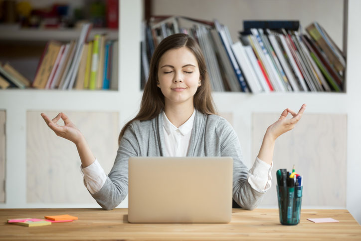 taking time to meditate at her desk